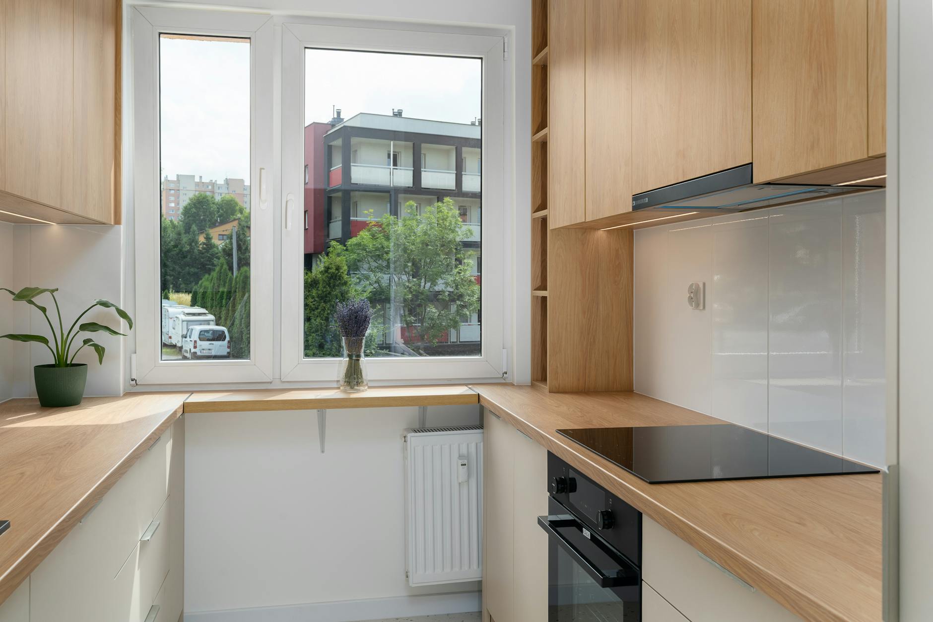 Nowoczesny aneks kuchenny z drewnianymi szafkami i widokiem na Kraków