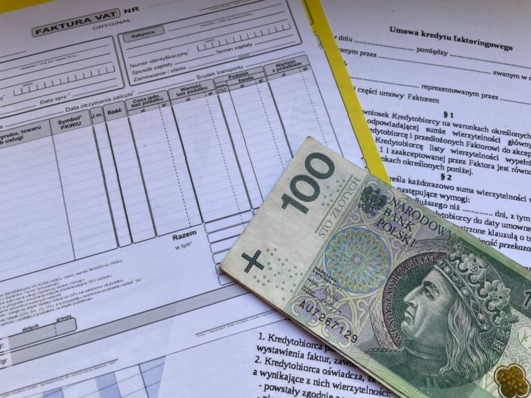 100-złotowy banknot na dokumentach finansowych i fakturach